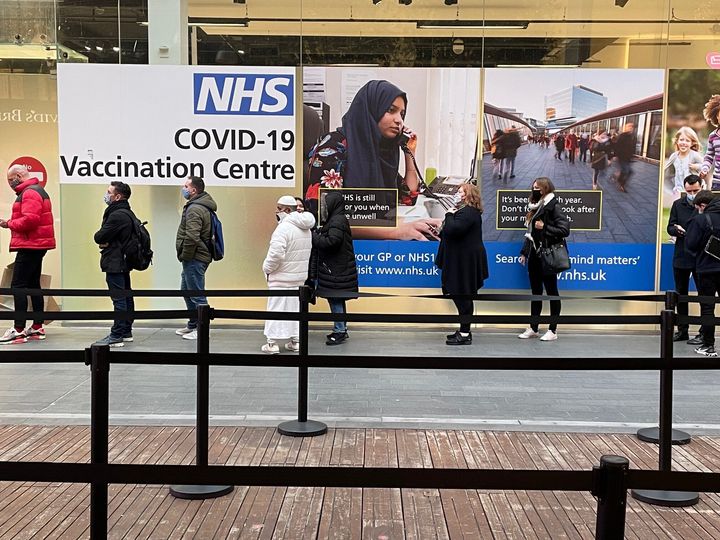 People queue at a Covid Vaccination Centre at the Westfield shopping centre in Stratford, east London.