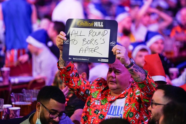 Fan holding a sign mentioning Boris Johnson during the World Darts Championship at Alexandra Palace, London on Monday.
