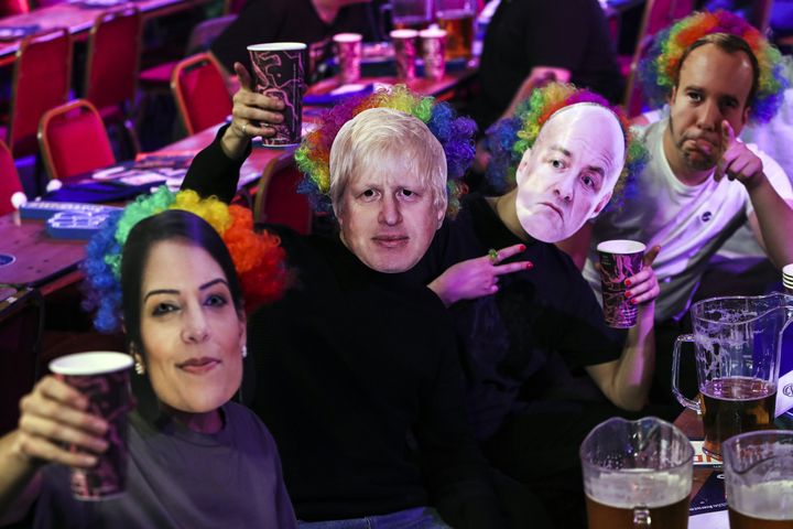 Spectators wear masks that show the faces of Priti Patel, Boris Johnson, Dominic Cummings and Matt Hancock last week.
