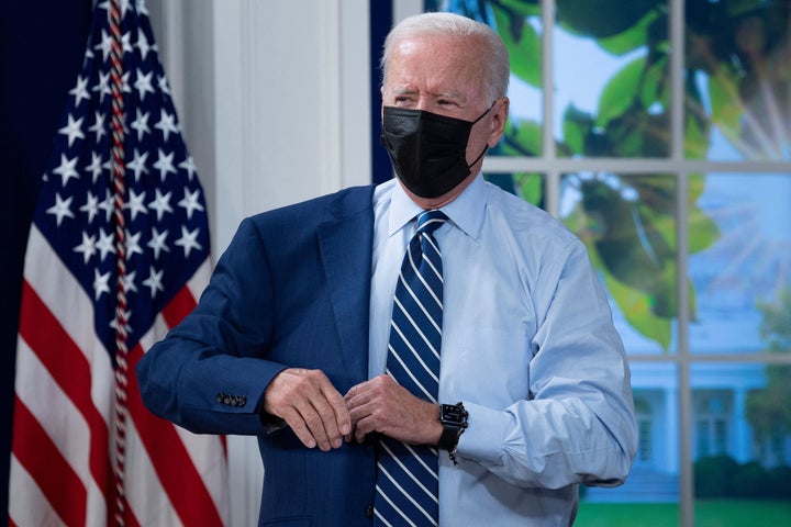 President Joe Biden puts on his suit jacket after receiving a booster shot of the Pfizer coronavirus vaccine on Sept. 27. His speech Tuesday about the omicron variant included an announcement about free at-home tests.