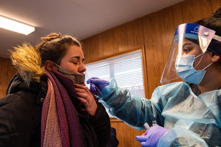 A medical worker performs a PCR test on a woman who wanted to be tested for Covid-19 at East Boston Neighborhood Health Center in Boston, Massachusetts. 