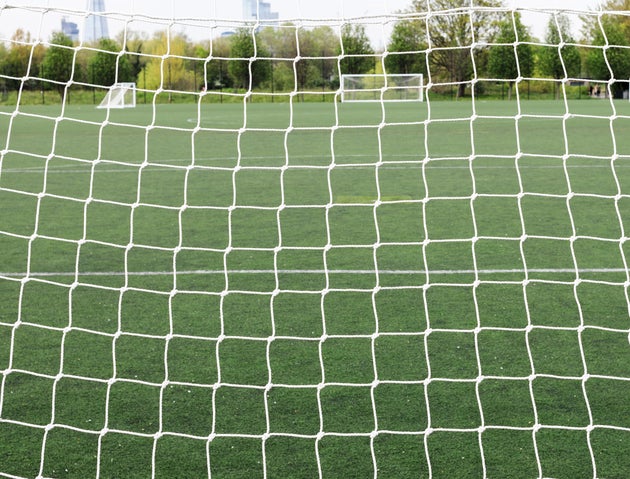 UK, London, Southwark Park, close up of net with empty leisure field behind