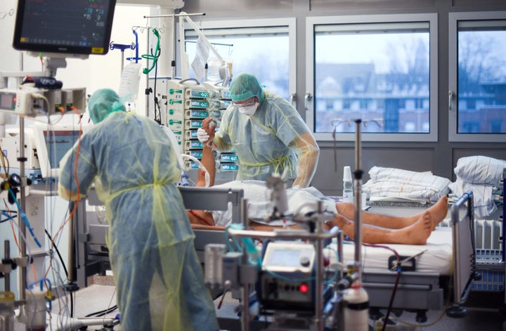 Personal sanitario atiende a un paciente en una UCI. Imagen de archivo.