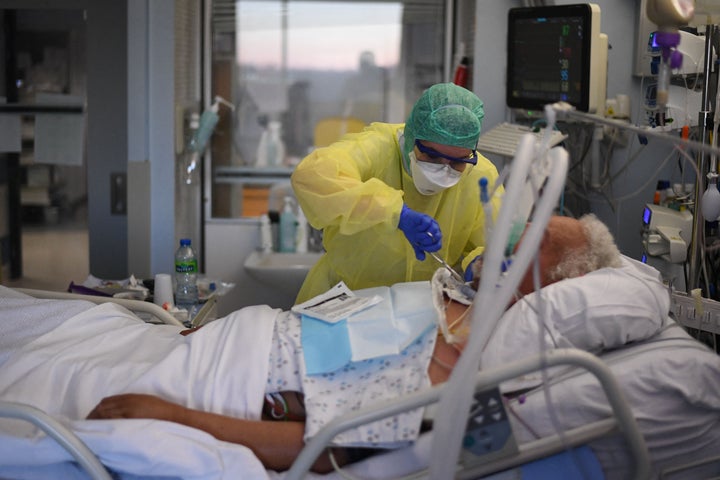 Un trabajador sanitario atiende a un paciente de covid-19.