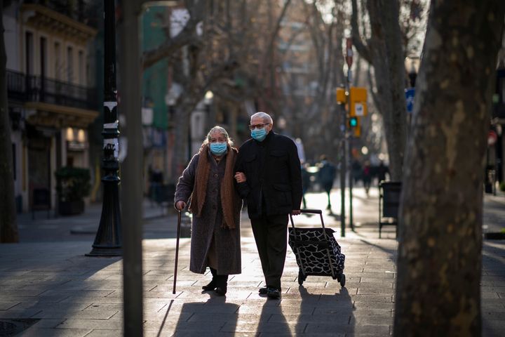 Una pareja con mascarilla camina por una calle de Barcelona. 