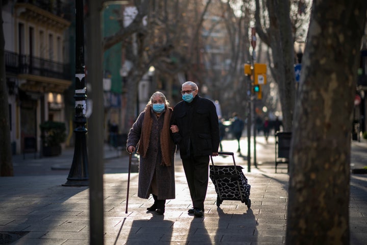 Una pareja con mascarilla camina por una calle de Barcelona.