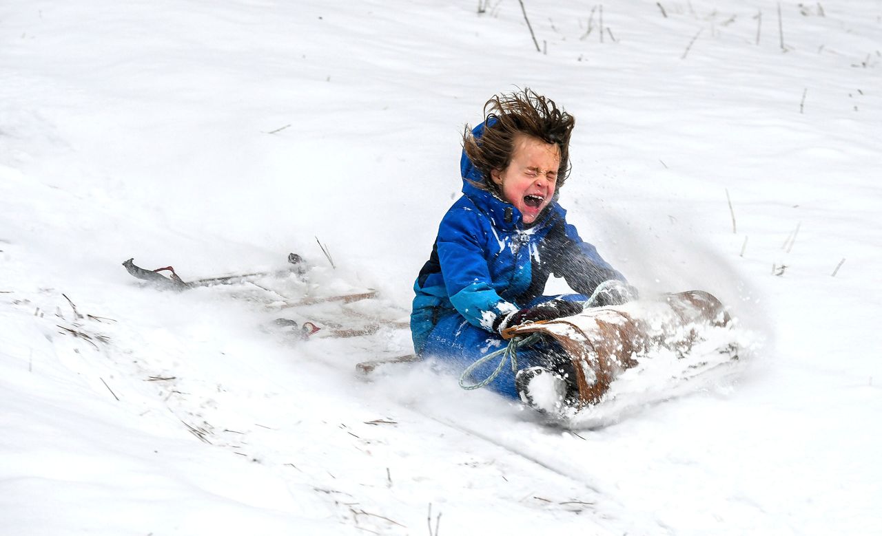 Corn Mayer, 8, takes a ride down a slope at Underhill Park in Spokane, Washington, on Dec. 20, 2021, on a wooden toboggan that has been in his grandmother's family since the ed1960s.
