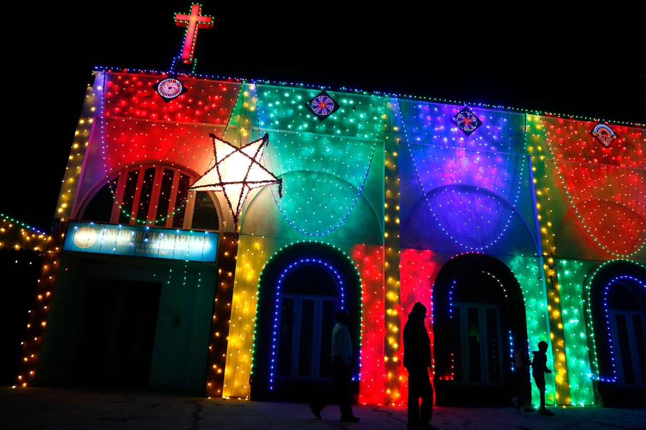 People walk past an illuminated church ahead of Christmas in Ahmedabad, India, on Wednesday. 
