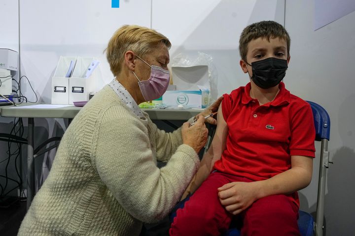 Ένας παιδίατρος χορηγεί μια δόση του εμβολίου Pfizer στον οκτάχρονο Ντιμίτρι Μαρκ