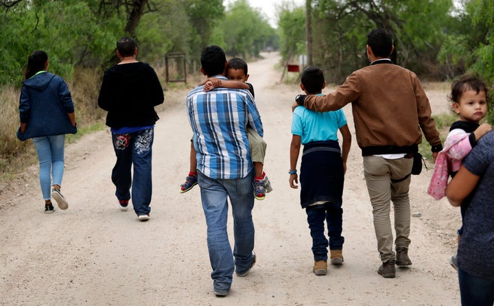 FILE - A group of migrant families walk from the Rio Grande, the river separating the U.S. and Mexico in Texas, near McAllen, Texas, March 14, 2019. A Biden administration effort to reunite children and parents who were separated under President Donald Trump's zero-tolerance border policy has made increasing progress as it nears the end of its first year. The Department of Homeland Security planned Thursday, Dec. 23, to announce that 100 children, mostly from Central America, are back with their families and about 350 more reunifications are in process after it adopted measures to enhance the program. (AP Photo/Eric Gay, File)