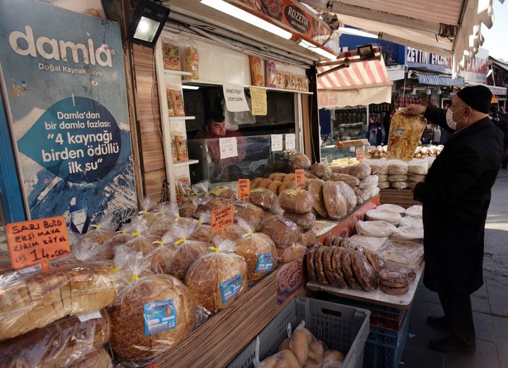 Περαστικός κοιτάζει με δέος τις τιμές στο ψωμί στην Άγκυρα, τη Δευτέρα 13 Δεκεμβρίου 2021. Ο πληθωρισμός καλπάζει, όπως και η ανεργία, καθώς οι τιμές στα καύσιμα και στα καταναλωτικά αγαθά εκτοξεύονται, λόγω της ιστορικής υποχώρησης της λίρας. Μεταξύ αυτοσχεδιασμού και μάχης για πολιτική επιβίωση, ο Ερντογάν έχει κηρύξει "ανένδοτο" εναντίον των εχθρών της τουρκικής οικονομίας... (AP Photo/Burhan Ozbilici)
