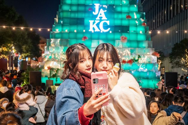 2020年のクリスマスイブ。上海で、クリスマス仕様に彩られたイルミネーションを前に写真を撮る女性たち