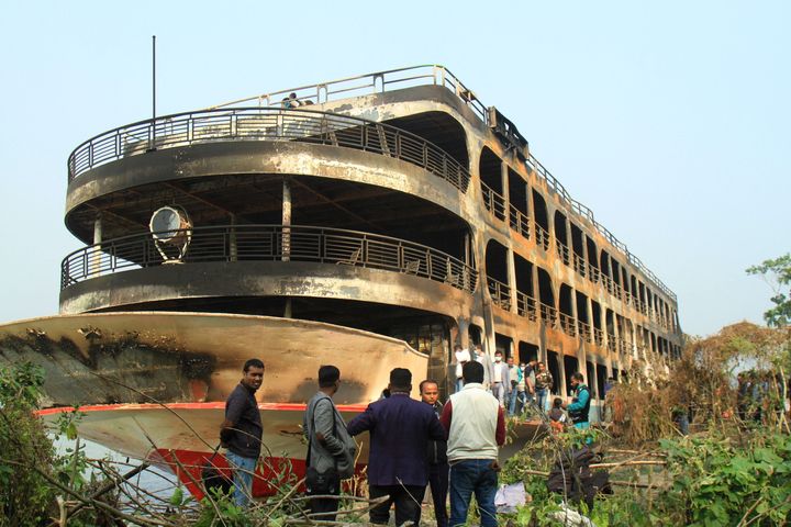 A burnt-out ferry is anchored along a coast a day after it caught on fire killing at least 39 people in southern Bangladesh on Dec. 24, 2021.