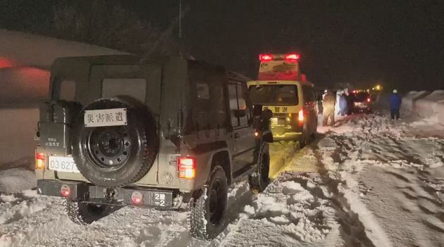 関越自動車道の大和パーキングエリア付近で、立ち往生した車の救助に向かう陸上自衛隊員ら＝2020年12月17日夜［防衛省統合幕僚監部提供］