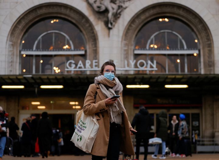 Μια γυναίκα που φοράει μάσκα στέκεται μπροστά από την κύρια είσοδο του σιδηροδρομικού σταθμού Paris Gare de Lyon ενόψει των Χριστουγέννων, εν μέσω της εξάπλωσης της πανδημίας της νόσου του κορονoϊού (COVID-19), στο Παρίσι, Γαλλία, 24 Δεκεμβρίου 2021. 