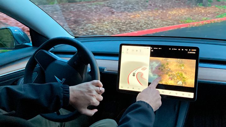 Ο Βινς Πάτον, νέος ιδιοκτήτης Tesla, δείχνει στις 8 Δεκεμβρίου 2021, τον τρόπο με τον οποίο μπορεί να παίξει βιντεοπαιχνίδια στην κονσόλα του οχήματος ενώ οδηγεί. Οι ΗΠΑ ξεκίνησαν επίσημη έρευνα μετά από καταγγελία ότι τα οχήματα της Tesla επιτρέπουν στους οδηγούς να παίζουν βιντεοπαιχνίδια στην κεντρική οθόνη αφής ενώ οδηγούν.