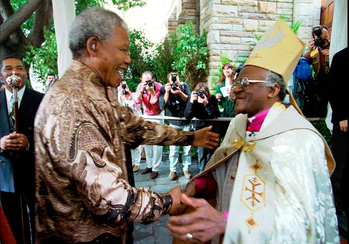 Desmond Tutu, right, greets President Nelson Mandela at a service in Cape Town, Sunday June 23, 1996 held to celebrate the end of Tutu's tenure as leader of the Anglican Church in South Africa. (AP Photo/Guy Tillim, File)