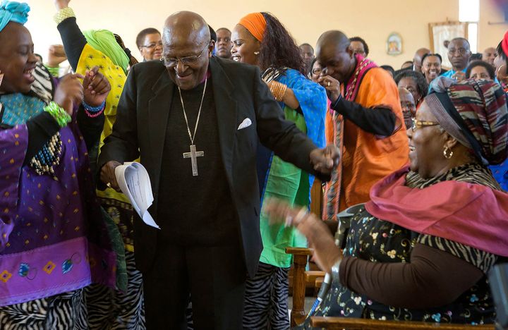 Desmond Tutu, en el centro, comienza a bailar después de renovar sus votos matrimoniales con su esposa de 60 años, Leah, a la derecha, durante un servicio en Soweto, Johannesburgo, agosto de 2015 (Foto AP, Archivo).