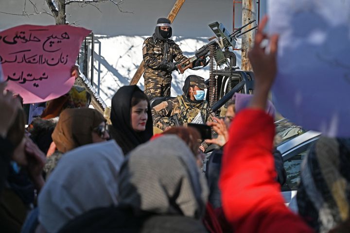 女性の就労や教育、政治参加を求めて抗議活動をする女性たちを監視するタリバンの兵士（2021年12月16日）
