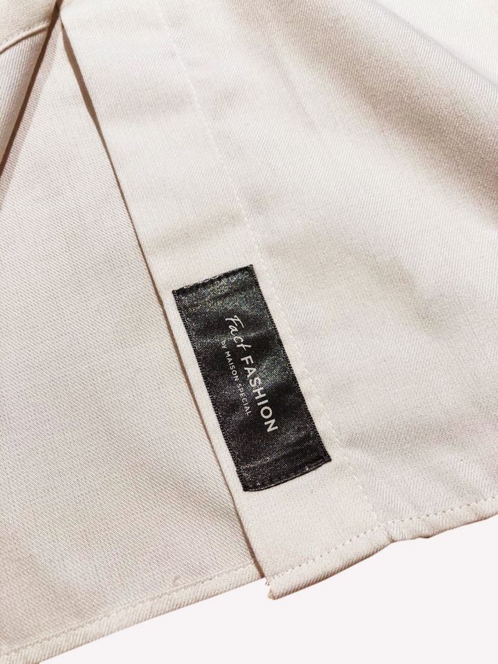 NEW BASIC SHIRT DRESSのタグは裾に縫いつけている。
