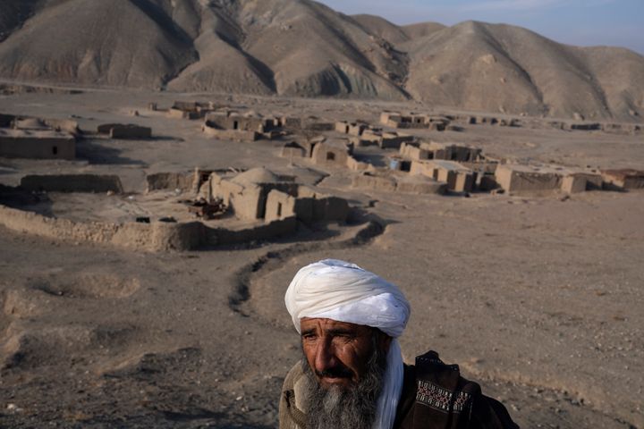 65-year-old Mohammad Ayoub, the only male left after all the younger men tried their luck leaving to Iran, stands in front Jar-e Sawz the village that he lives outskirts of Herat, Afghanistan, on Saturday, Nov. 27, 2021. (AP Photo/Petros Giannakouris)