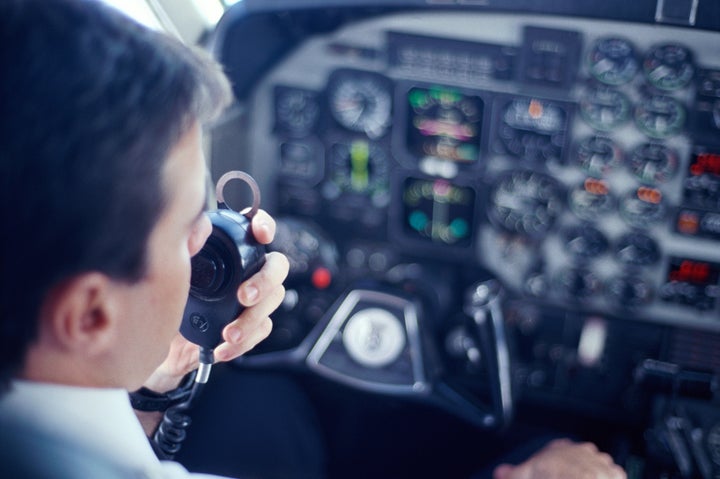 Piloto hablando por la radio del avión durante un vuelo.