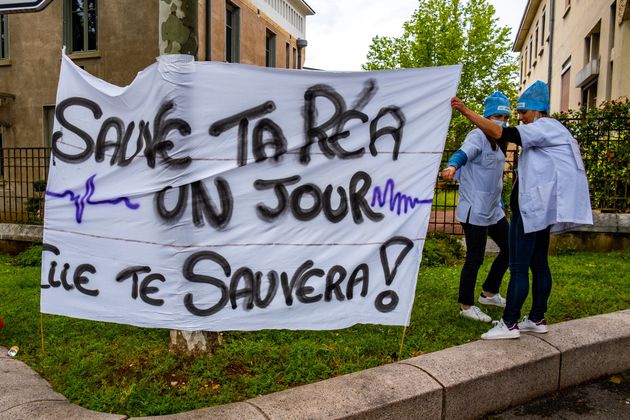 Des infirmiers des services de réanimation des hôpitaux en grève pour la revalorisation de leurs salaires rassemblés devant l'entrée de l'hôpital Edouard Herriot le 11 mai 2021 à Lyon.