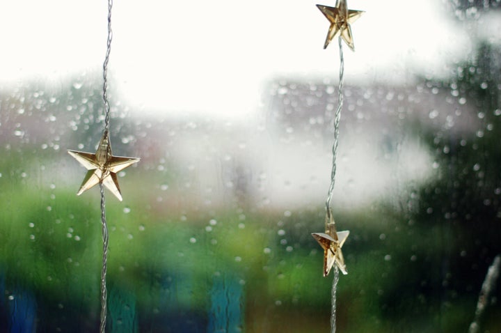 christmas light decoration in a window, seen on a rainy day