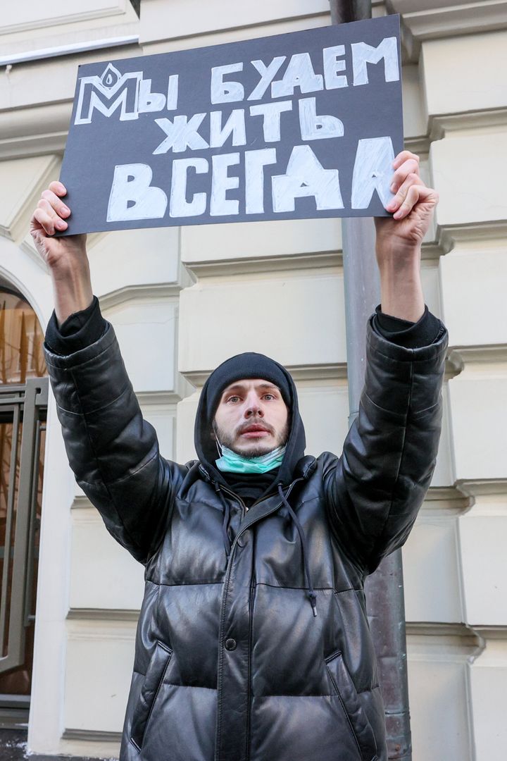 Ένας υποστηρικτής της Memorial Society κρατά ένα πλακάτ "Θα ζούμε για πάντα" έξω από το Ανώτατο Δικαστήριο της Ρωσίας κατά τη διάρκεια μιας ακρόασης των επιχειρημάτων του Γραφείου του Ρωσικού Γενικού Εισαγγελέα και του διεθνούς δημόσιου οργανισμού Memorial Society.