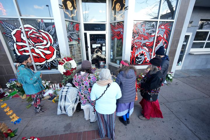 Mourners gather outside the door of a tattoo parlor along South Broadway, Tuesday, Dec. 28, 2021 in Denver, one of the scenes of a shooting spree that left six people dead—including the suspected shooter Monday evening—and left two more people wounded. 