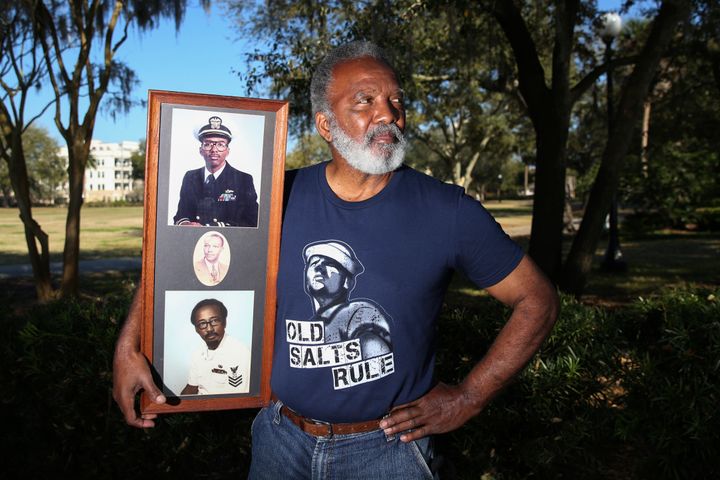 Reuben Green, a retired Black Naval officer, holds photos of, from bottom, his father, grandfather and himself, top, at Memorial Park in Jacksonville, Fla., Friday, Feb. 26, 2021. (AP Photo/Gary McCullough)