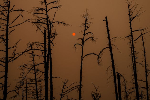 TOPSHOT - This picture taken on July 27, 2021, shows the sunlight filtered through smoke from burning...