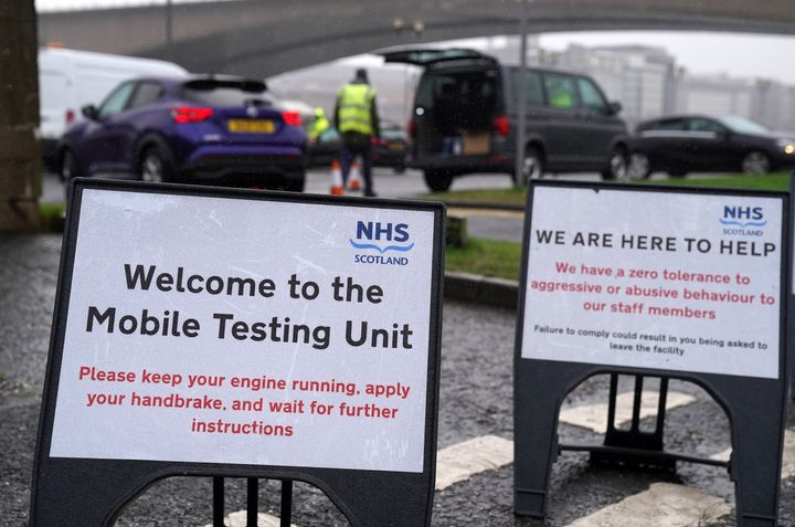 Signs at a mobile Covid-19 test site in Glasgow, Scotland, where people have been asked to reduce their social contact as much as possible by meeting in groups of no more than three households.