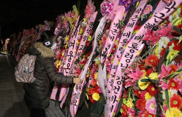 박근혜 전 대통령의 특별사면을 하루 앞둔 30일 오후 한 지지자가 서울 강남구 삼성서울병원 앞에 박 전 대통령의 사면을 축하하는 화환을 정리하고
