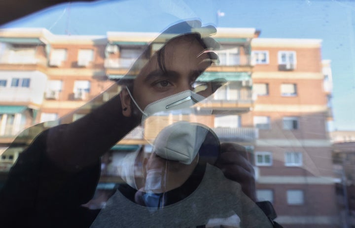 Una persona confinada mira por su ventana