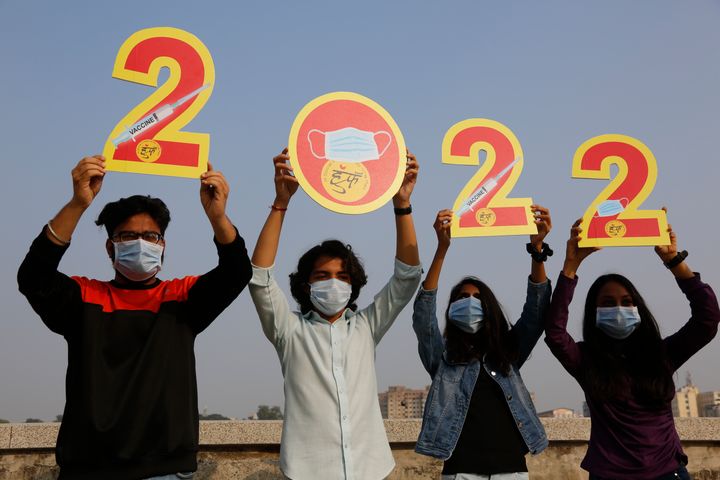 Indians, wearing face masks to help curb the spread of the coronavirus, hold cutouts to welcome 2022 on New Year's Eve in Ahmedabad, India, on Friday, Dec. 31, 2021. (AP Photo/Ajit Solanki)