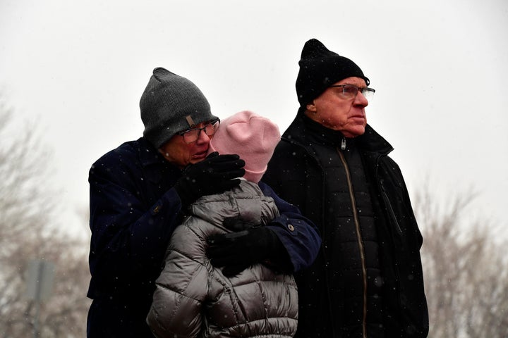 Jordan Hymes gets a hug from her grandmother Nancy Grigon, left, as her grandfather Guy, right, looks towards their burned out subdivision in the Coal Creek Ranch subdivision in the aftermath of the Marshall Fire on December 31, 2021 in Louisville, Colorado.