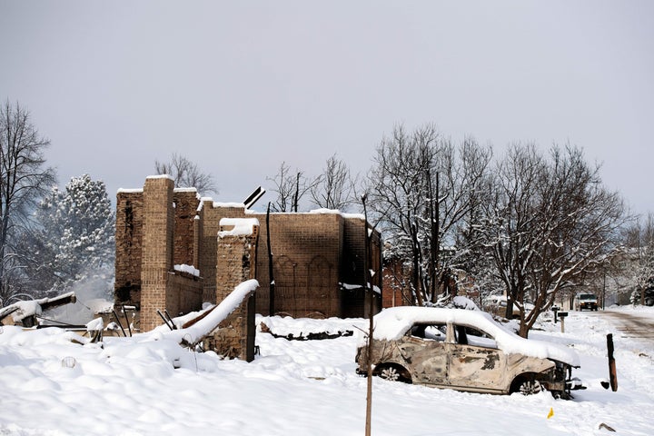 A snow covered car burned by the Marshall Fire is seen near destroyed homes in the Rock Creek neighborhood of Superior in Boulder County, Colorado.