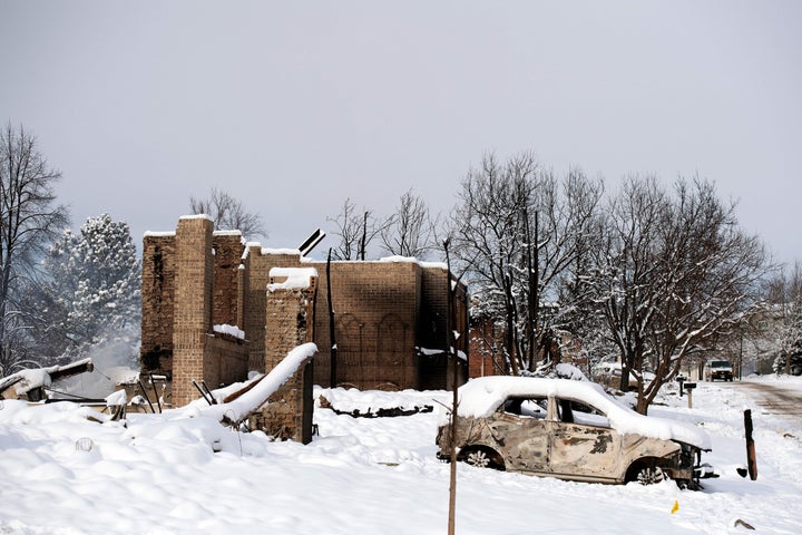 A snow covered car burned by the Marshall Fire is seen near destroyed homes in the Rock Creek neighborhood of Superior in Boulder County, Colorado. 