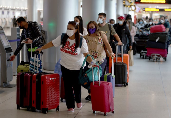 Masked travelers make their way through Miami International Airport on December 28 in Miami.