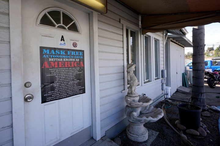 A sign against wearing masks to slow the spread of the coronavirus covers the office door of Fowler's Pool Services and Supply Inc in Spring Valley, Calif., on Jan. 7, 2021.