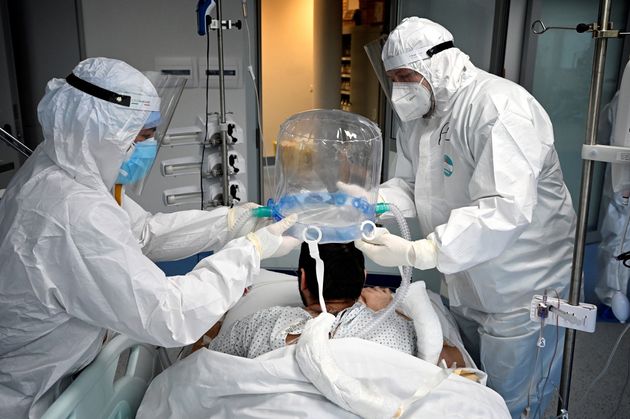 TOPSHOT - Medical staff members help a patient to wear a new non-invasive technology that can reduce...