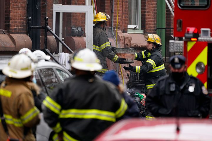 Philadelphia firefighters clear debris from the scene of a deadly row house fire, Wednesday, Jan. 5, 2022, in the Fairmount neighborhood of Philadelphia. Officials say firefighters and police responded to the fire at a three-story rowhouse early Wednesday around 6:40 a.m. and found flames coming from the second-floor windows. (AP Photo/Matt Rourke)