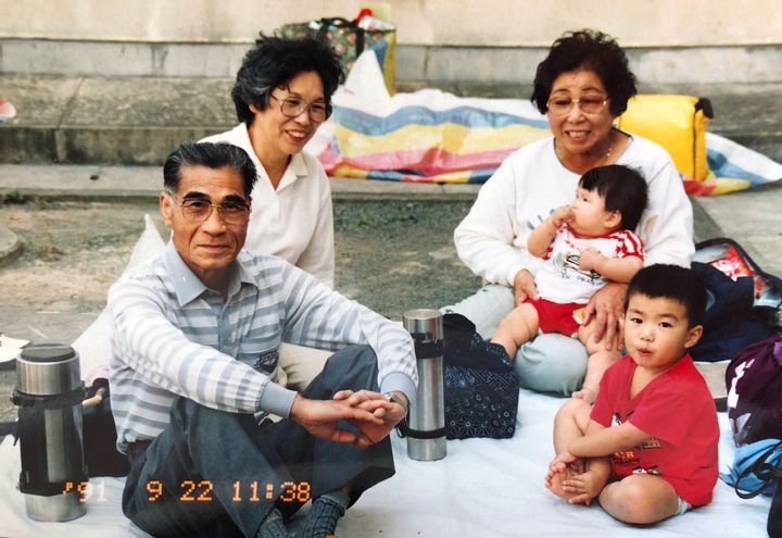 2歳の頃の曽宮さん（右下）と、油絵の作者である母方の祖父の髙嶋国松さん。左上が母方の祖母。右上が父方の祖母で、抱っこされているのは曽宮さんの妹。（1991年9月撮影）