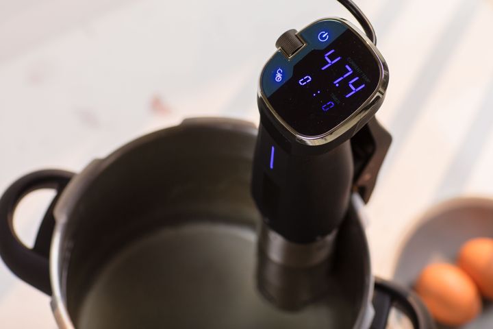 The control panel of a sous vide circulator shows the controlled temperature and time settings.