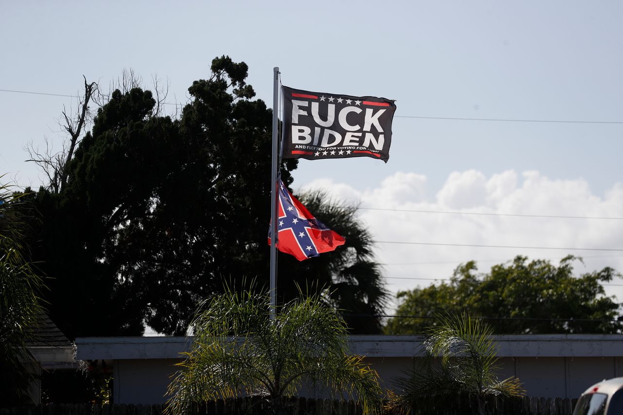 A expletive-bearing flag denigrating President Joe Biden and a Confederate flag fly over a home in Brevard County, Florida, on Dec. 16.