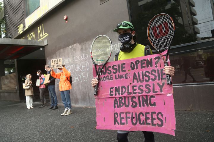 Υποστηρικτές των ανθρωπίνων δικαιωμάτων διαδηλώνουν δίπλα σε υποστηρικτές του Τζόκοβιτς έξω από το ξενοδοχείο όπου παραμένει ο Σέρβος τενίστας στην Μελβούρνη, όπως και πολλοί μετανάστες. Οι υποστηρικτές των μεταναστών φωνάζουν για την κακομεταχείρισή τους, την ώρα που η Αυστραλία καλείται να αποφασίσει εάν θα επιτρέψει την είσοδο παικτών που δεν έχουν εμβολιαστεί, προκειμένου να λάβουν μέρος στο διάσημο τουρνουά Australia Open. (AP Photo/Hamish Blair)