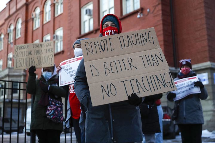 Members of the Chicago Teachers Union listen to speakers at a press conference outside of John Spry Community School in Chicago's Little Village neighborhood on Jan. 10, 2022.