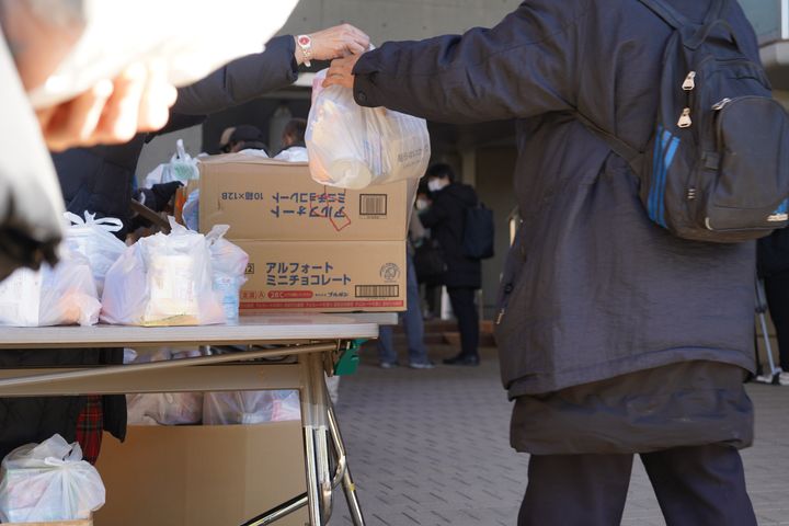 「年越し大人食堂」で食料を受け取る女性＝2021年12月30日、東京都千代田区の聖イグナチオ教会