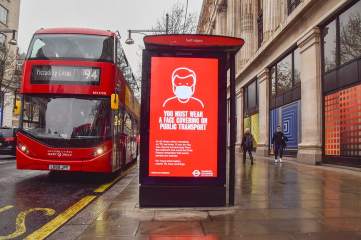 A display is seen on a bus stop on Oxford Street in London that informs people that they must wear a face covering on public transport as the Omicron variant of coronavirus continues to spread.